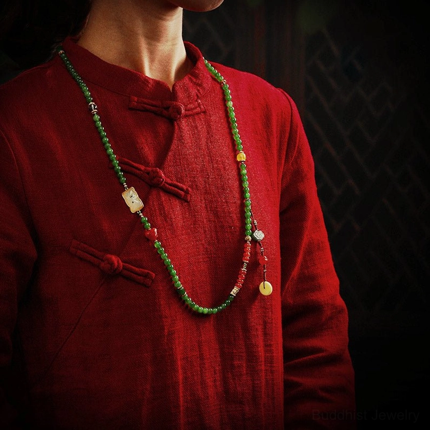 Slim jade bead necklace worn on torso with white square jade carving and hanging beads