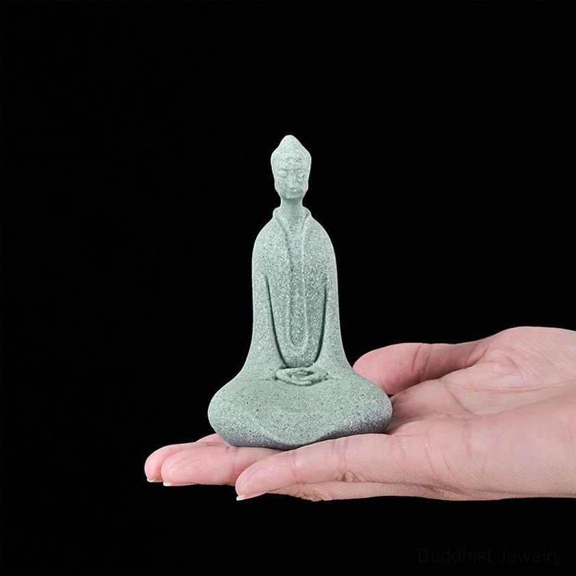 Compact Buddha statue held in human palm demonstrating portable size perfect for desk meditation and spiritual practice