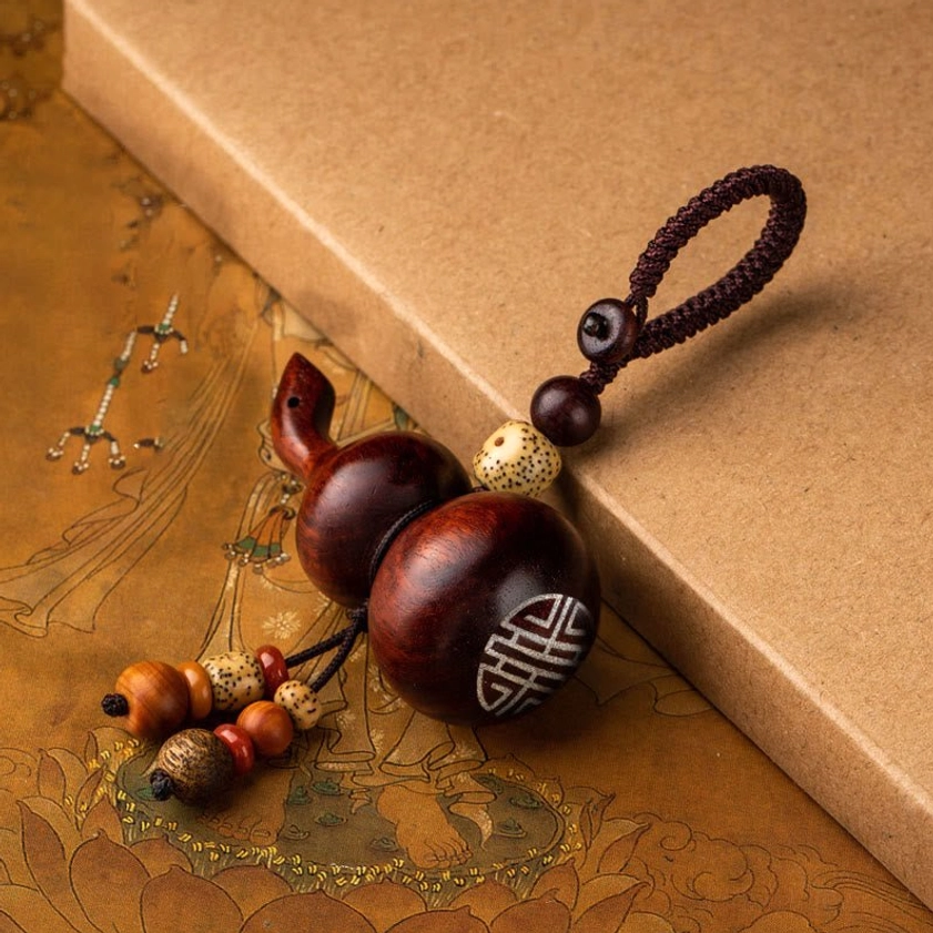 Small leaf red sandalwood horizontal gourd keychain with traditional engraving, representing longevity and spiritual cultivation in Buddhist practice