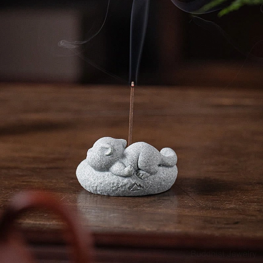 Smiling cat incense burner with golden socket and natural stone texture