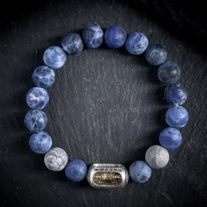 Sodalite and grey jasper Om Mani Padme Hum Buddhist bracelet with engraved copper mantra bead on black background