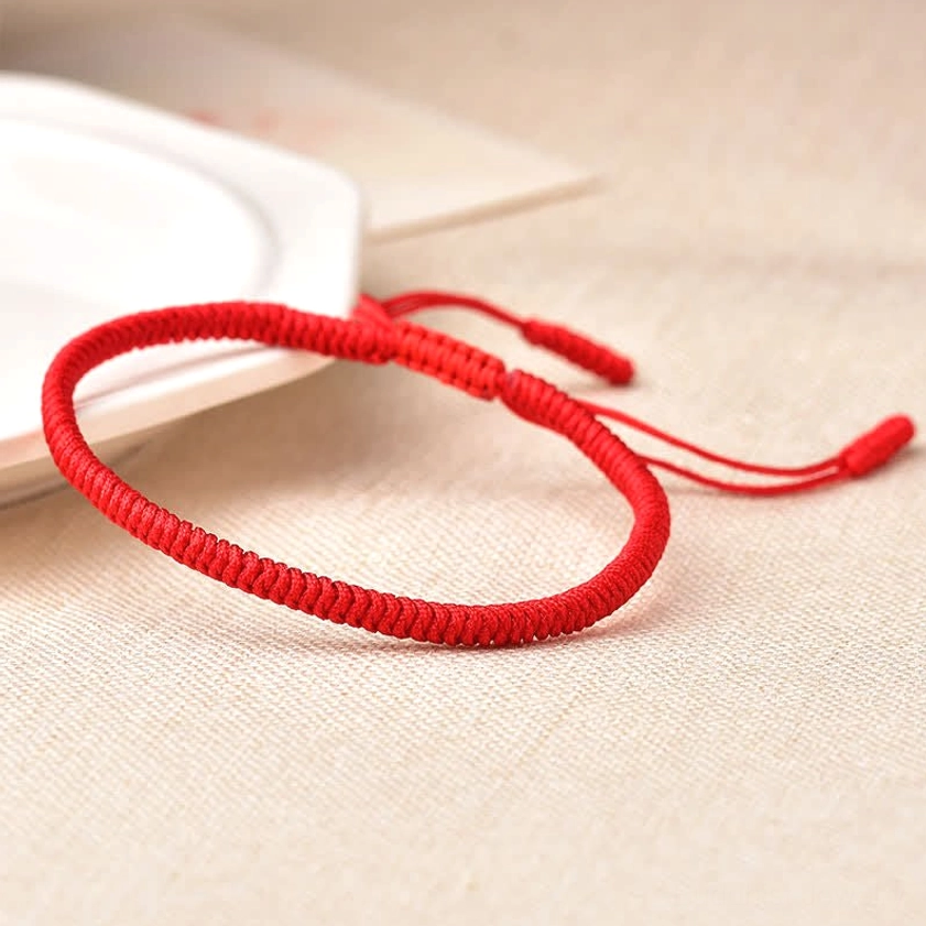 Bright red pure solid Buddhist string bracelet with traditional braided finish and adjustable pull cord closure