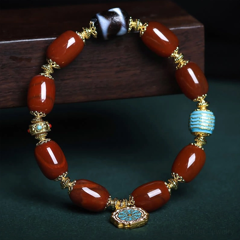Buddhist protection bracelet detail - close-up top view featuring turquoise spacer beads, South Red Agate barrels, and sacred Bagua symbol pendant