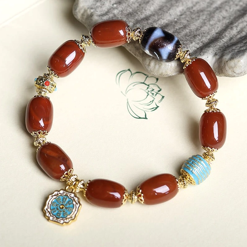 Full circle layout of South Red Agate Bagua Dzi Bead Bracelet on lotus print background - complete bracelet display
