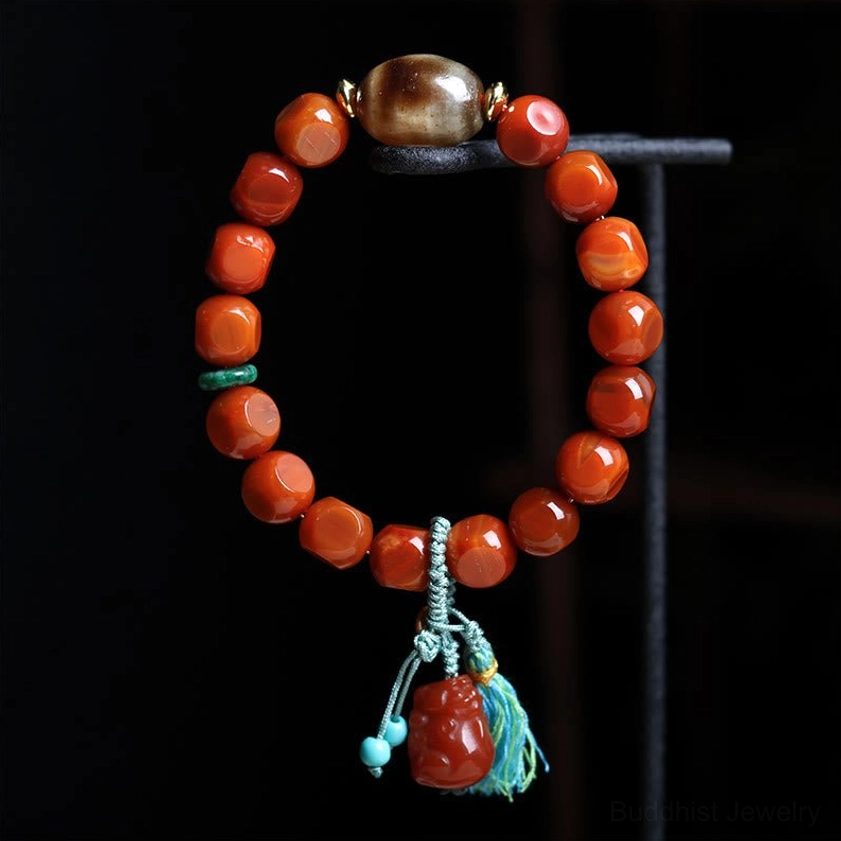 South Red Agate bracelet with round smooth red beads and brown central accent bead hanging on black metal display rack