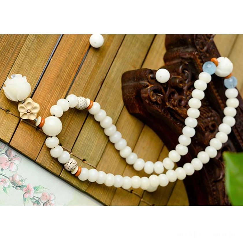 Bodhi seed bracelet flat lay with scattered beads and wooden lotus flower charms