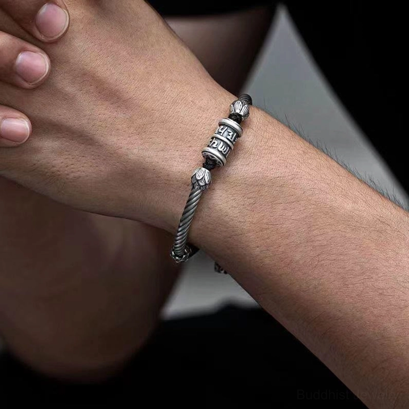 Om mani padme hum bracelet worn on male wrist, showing twisted silver accents and bead design in casual indoor setting