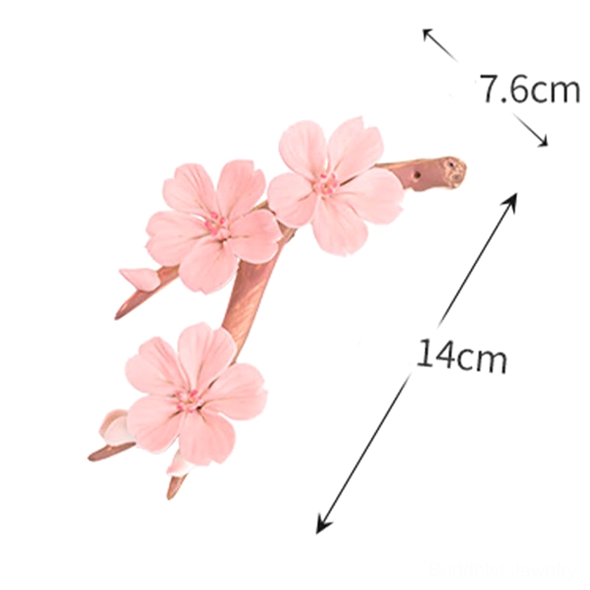 Ceramic incense burner with pink plum blossoms on natural branch base, peaceful spiritual decoration setup