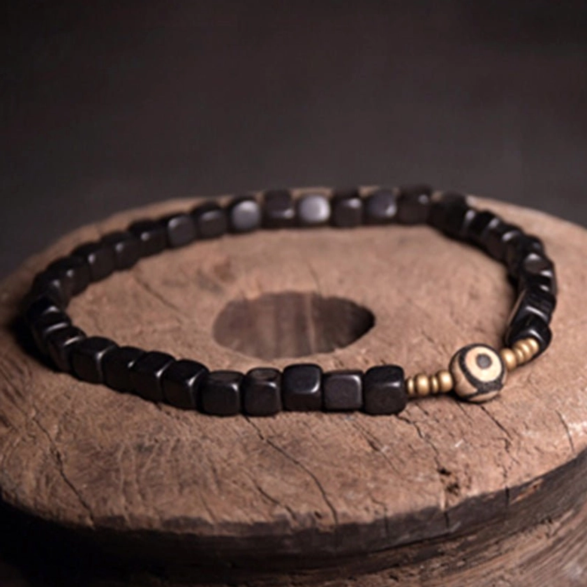 Square ebony wood beads bracelet with gold tone accents and nine-eye dzi bead charm