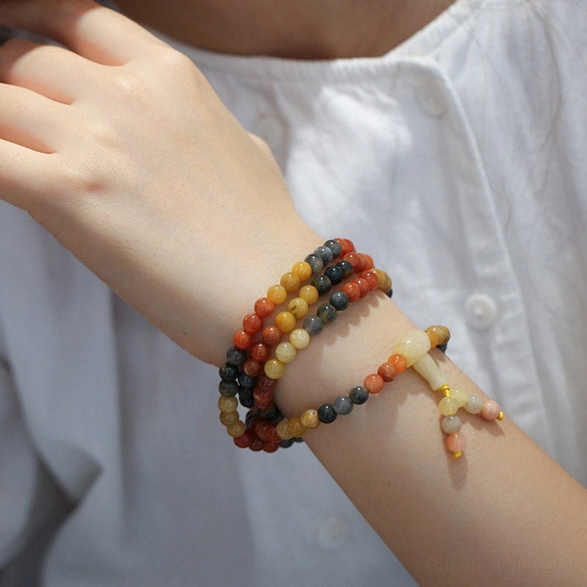 Single arm wearing two agate mala bracelets with jade tassel pendant - stack styling for Buddhist prayer beads