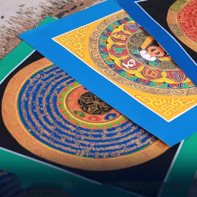Stacked handmade Buddhist thangka paintings with lotus patterns and sacred scripture borders in multiple colors