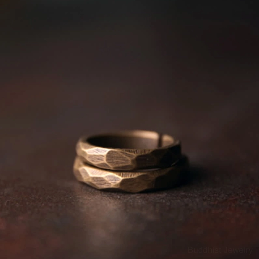 Stacked copper Buddhist wealth rings front view showing uniform faceted texture and antique finish