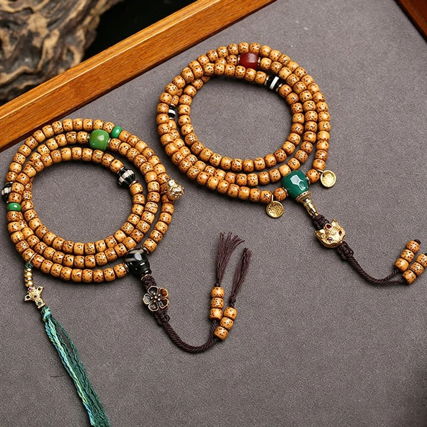 Two handcrafted 108-bead Buddhist malas displayed with wooden tray, tan spotted beads and green stone accents