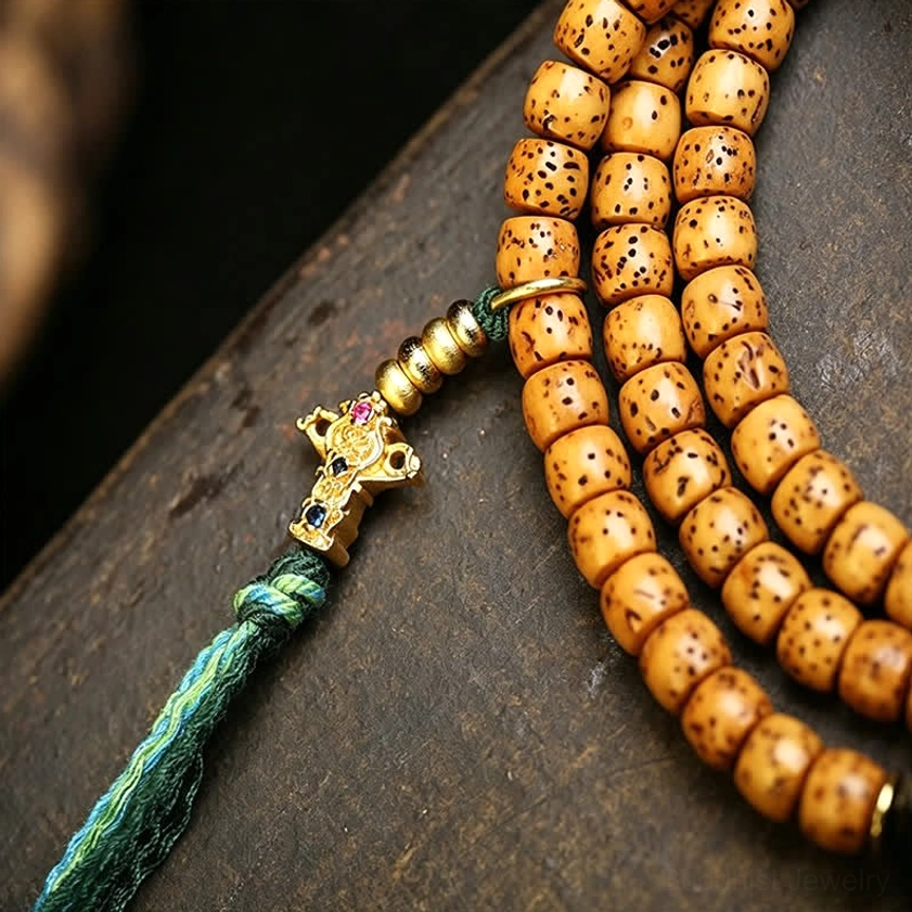 Close-up of 108 Star Moon Bodhi Seed prayer beads with green tassel and ornate metal guru bead