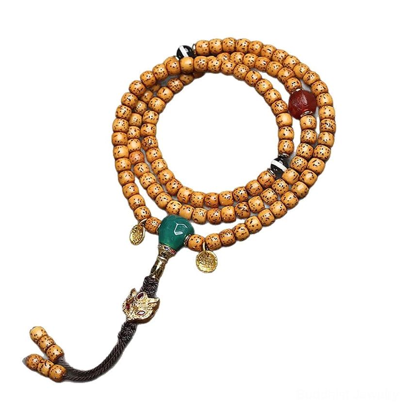 Buddhist prayer mala with tan Star Moon Bodhi Seeds and green stone accent bead on light background