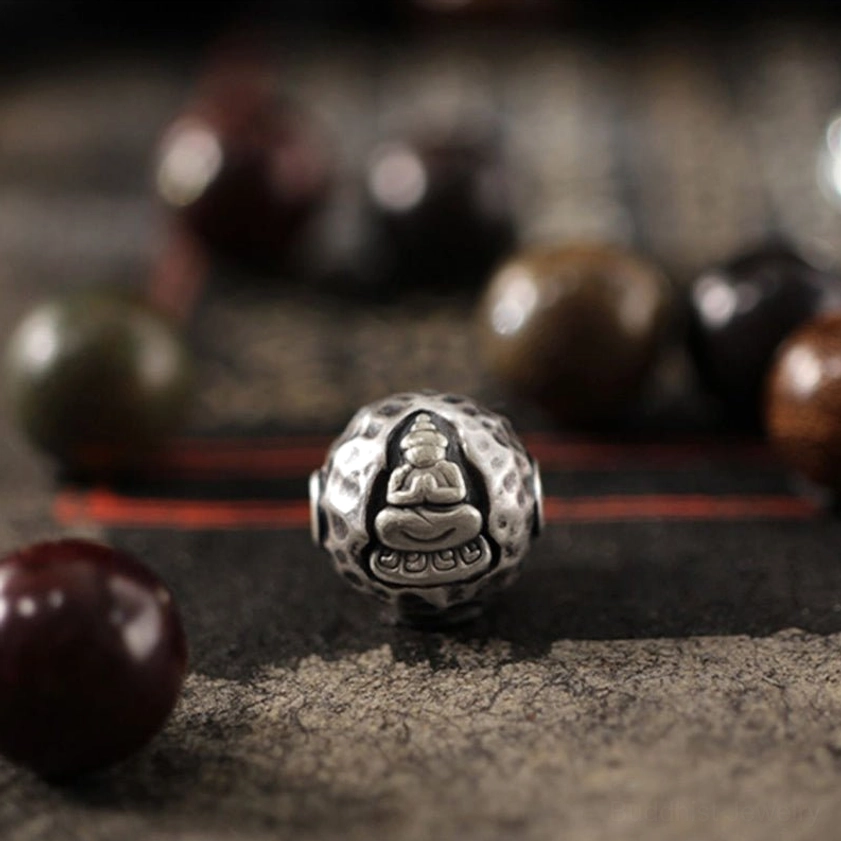 999 sterling silver Buddha meditation charm with embossed enlightenment figure and matte finish texture, flat lay detail shot