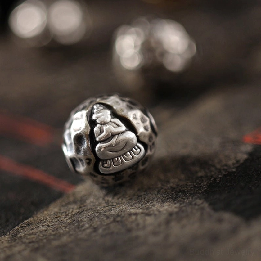 Single sterling silver Buddha bead with front-facing engraved meditation figure, textured matte surface detail for Buddhist bracelet charm