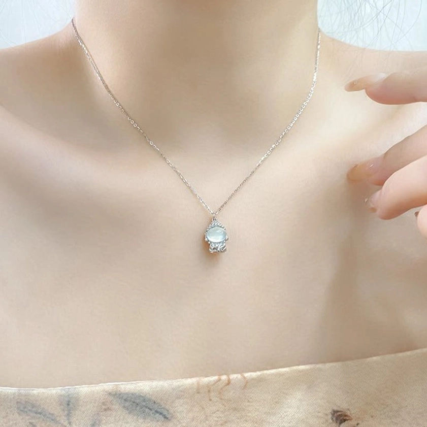 Model wearing delicate sterling silver Buddha pendant necklace on thin chain at neck, daily spiritual jewelry styling close-up