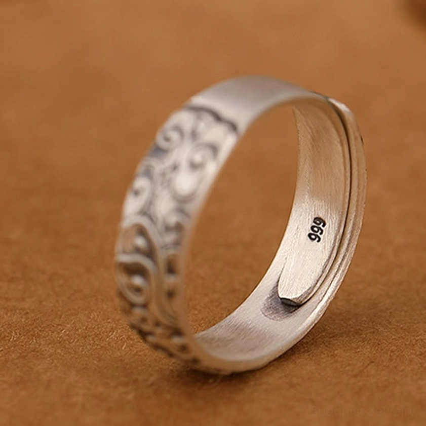 Multiple sterling silver Buddhist rings collection showing size consistency and quality craftsmanship of engraved lotus plum blossom and cloud designs