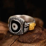 925 sterling silver Dzi bead ring with single-eye goddess symbol, adjustable size, vintage scroll engraving and gold-plated accents, front left perspective view