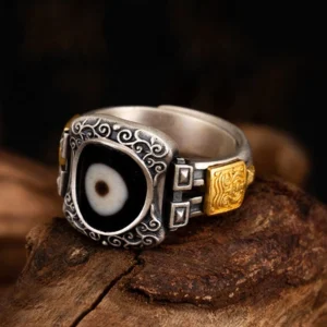 925 sterling silver Dzi bead ring with single-eye goddess symbol, adjustable size, vintage scroll engraving and gold-plated accents, front left perspective view