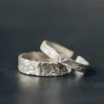 925 sterling silver couple rings with handcrafted hammered texture detail, top-down flat lay view