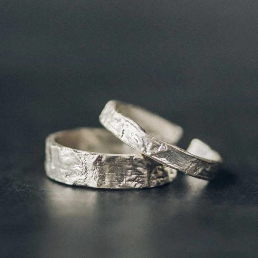 925 sterling silver couple rings with handcrafted hammered texture detail, top-down flat lay view