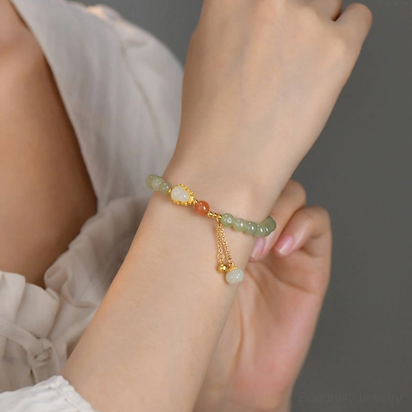 Sterling silver hetian jade bracelet worn close-up with gold chain accents