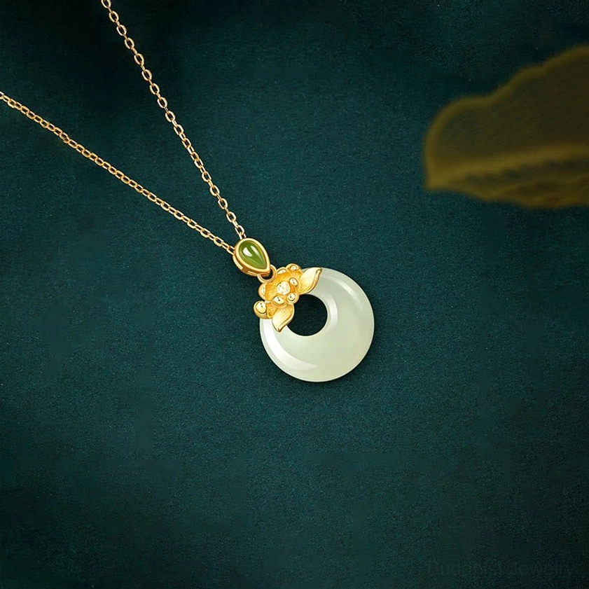 Sterling silver jade lotus pendant necklace, three-quarter view showcasing gold floral clasp and round jade charm