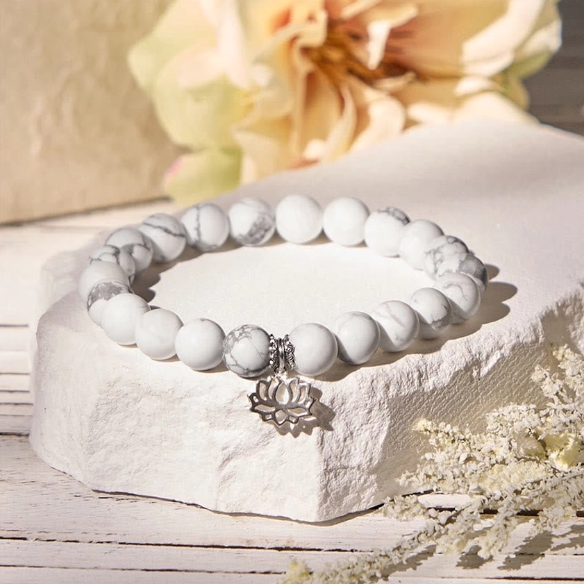 Close-up detail of sterling silver lotus pendant charm on white turquoise Buddhist prosperity bracelet