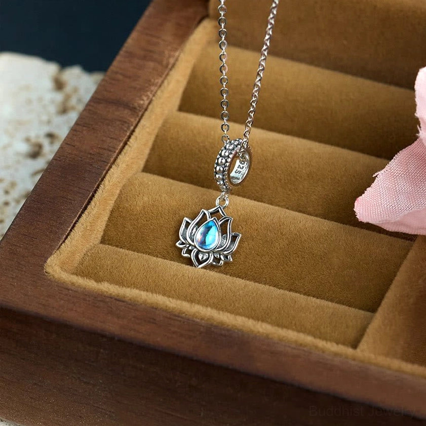 Delicate lotus moonstone silver necklace pendant on fine cable chain displayed in wooden jewelry box with pink accents