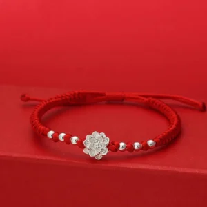 Sterling silver lotus charm with red string bracelet, adjustable knot closure, front flat lay view