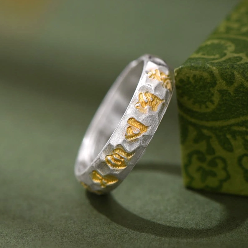 Buddhist mantra sterling silver ring with two-tone design and hammered texture, displayed with presentation box