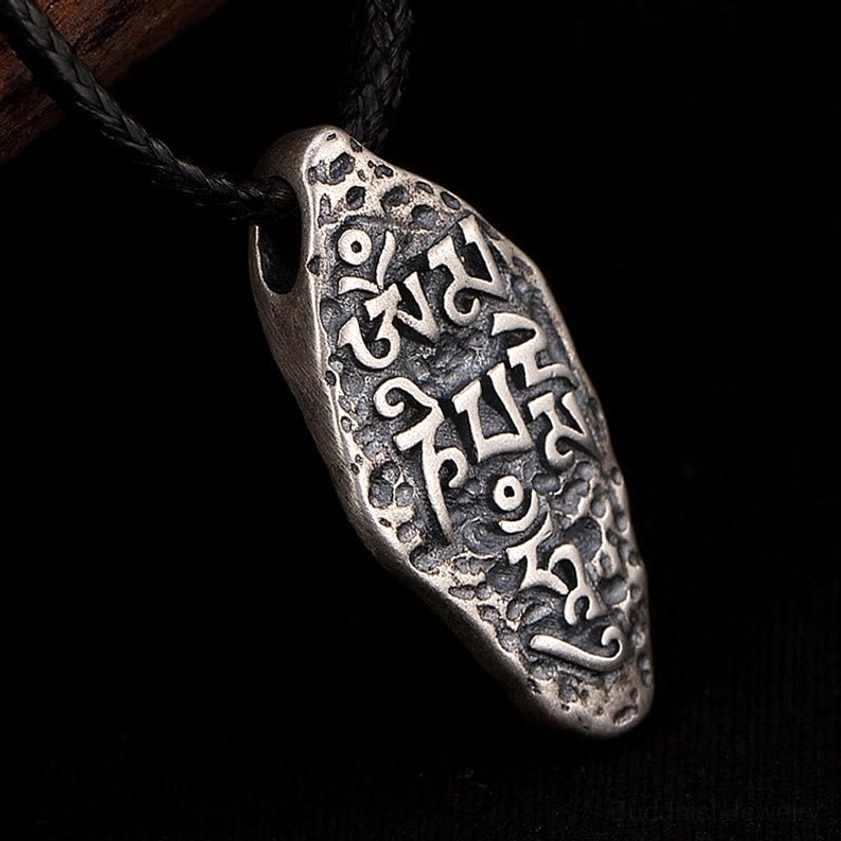 925 sterling silver Om Mani Padme Hum pendant necklace front view against black background, displaying full sacred mantra engravings with distressed patina