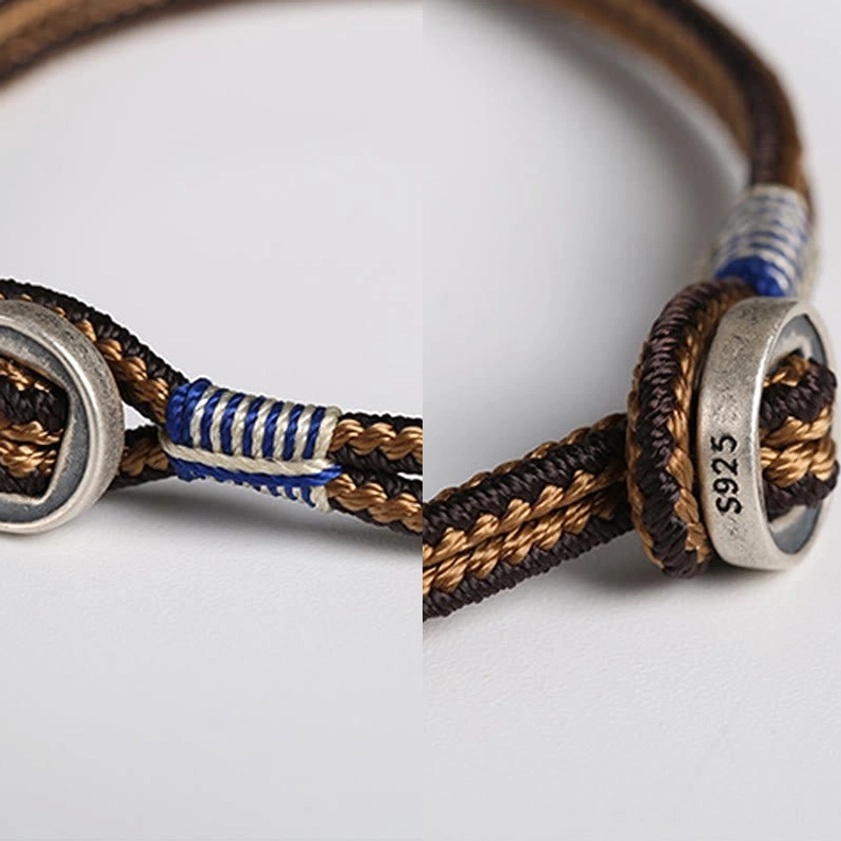 Extreme close-up detail of sterling silver Buddhist bracelet showing S925 hallmark engraved on metal buckle and blue white woven adjustment cord