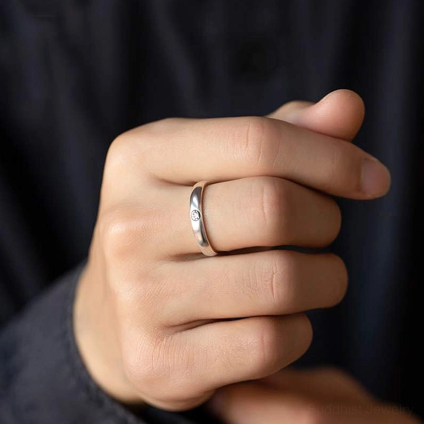 925 sterling silver zodiac natal buddha ring worn on finger, close-up detail view