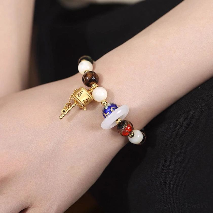 Sun stone Buddhist prayer bracelet worn on arm with blessing metal tag and hollow prayer wheel pendant