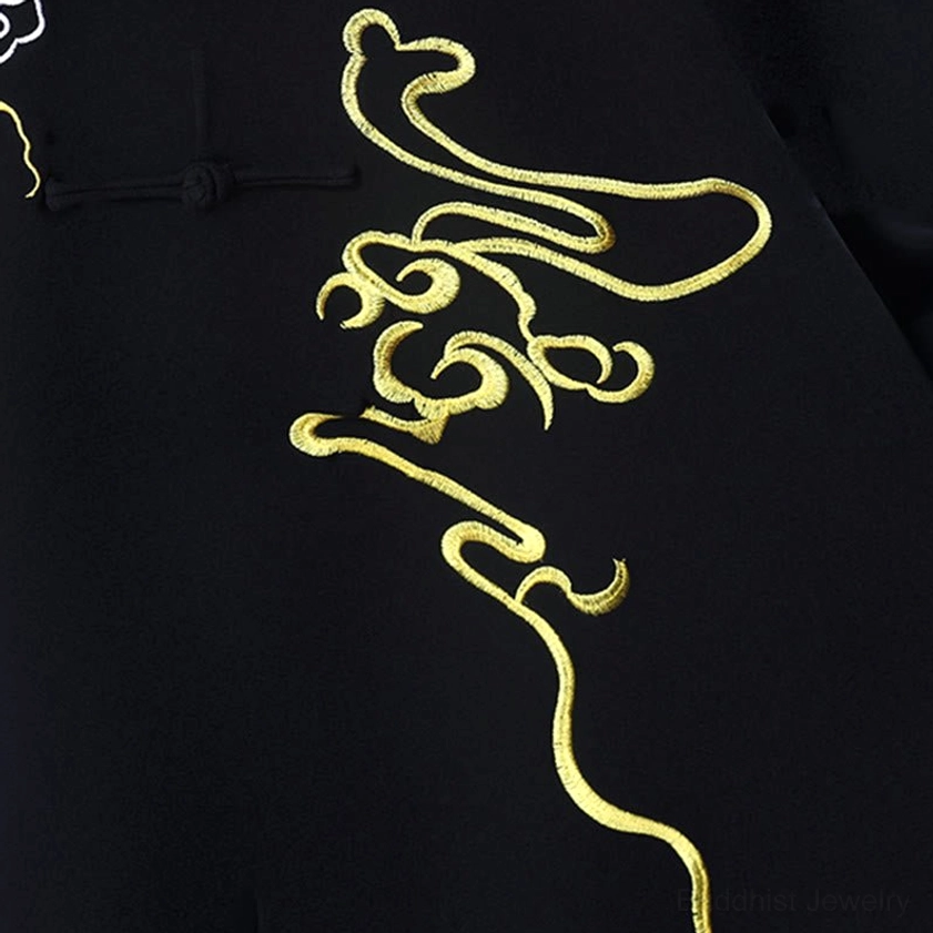 Close-up of golden cloud embroidery on black tai chi fabric