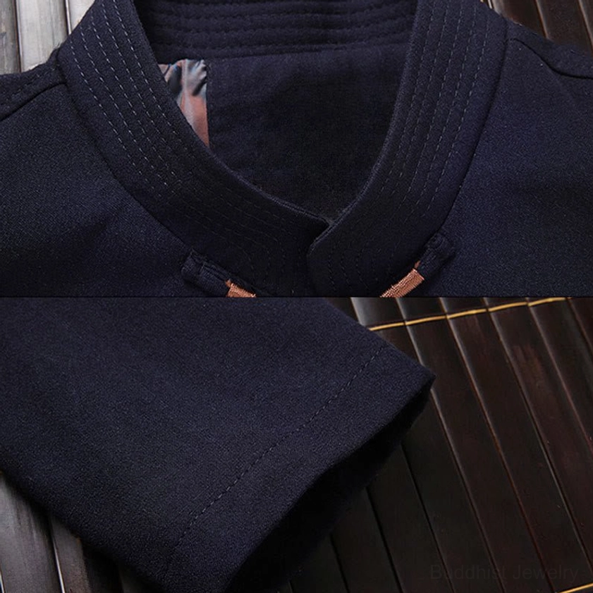 Close-up of dark navy Tang suit jacket fabric texture and stand collar detail on bamboo mat