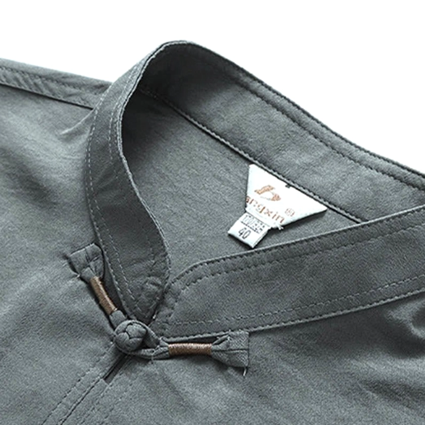 Close-up detail of grey Tang suit mandarin collar showing frog button and brand tag