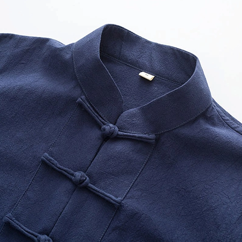 Close-up of Tang suit mandarin collar and traditional frog button closures on navy blue fabric