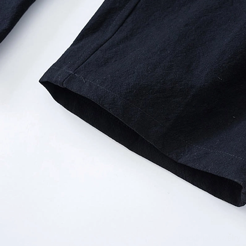 Tang suit pants hem detail showing straight-cut design and black cotton fabric construction