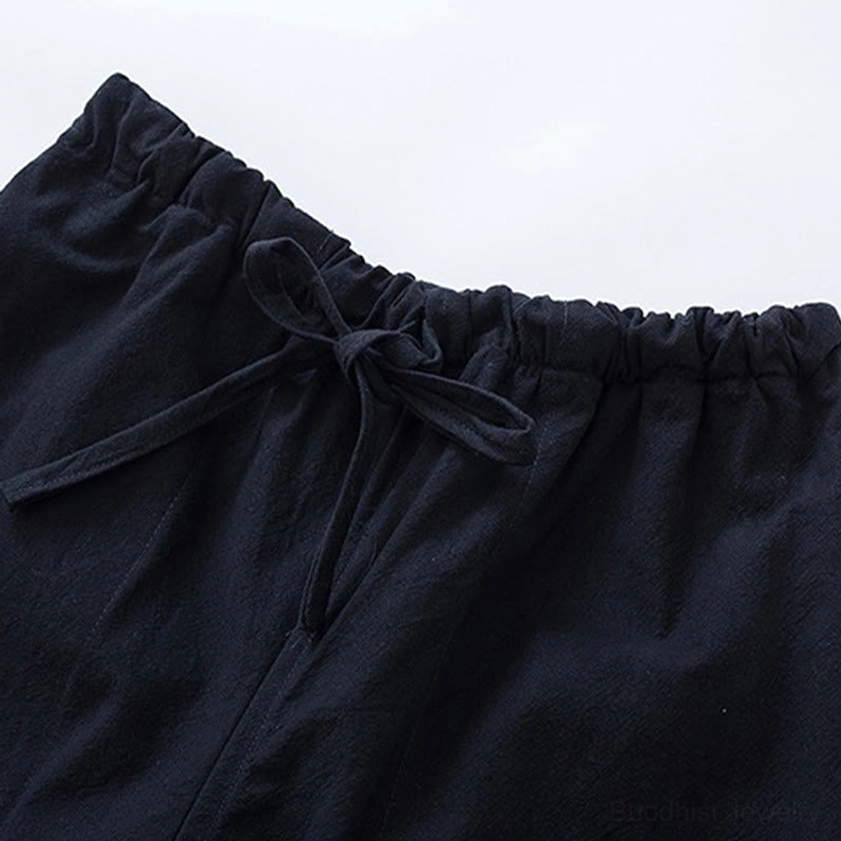 Close-up detail of Tang suit pants elastic waistband with drawstring closure and black cotton fabric