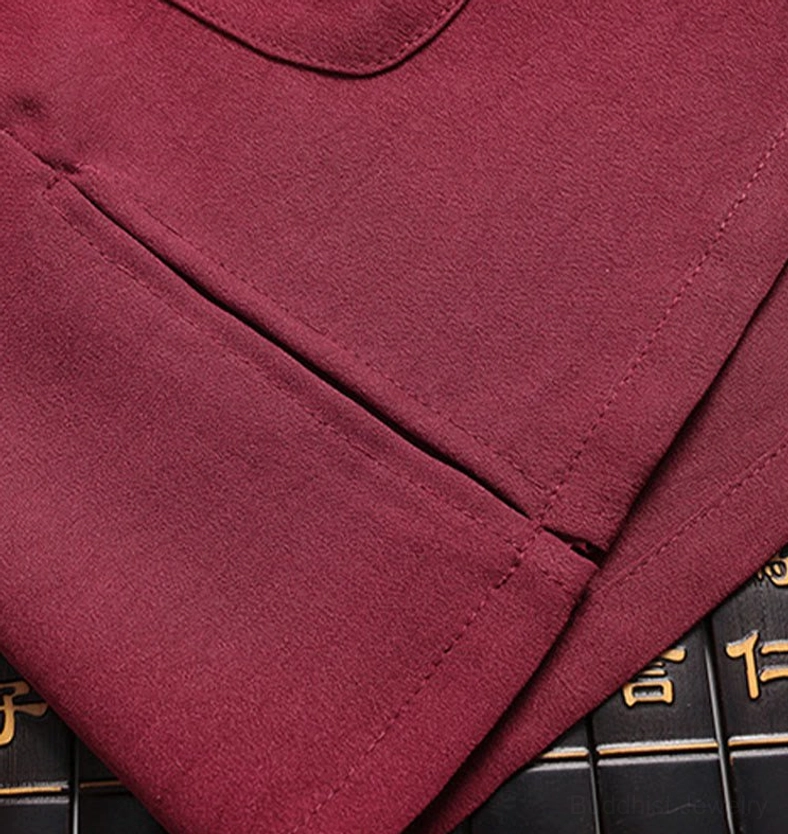 Tang suit pocket and seam close-up - flat lay showing patch pocket design with embroidered accent and neat side seam stitching on maroon fabric
