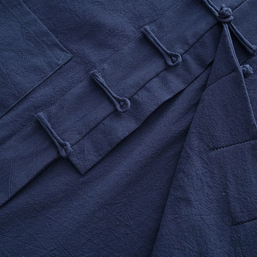 Tang suit side placket detail showing overlapping front design and frog button placement on navy fabric