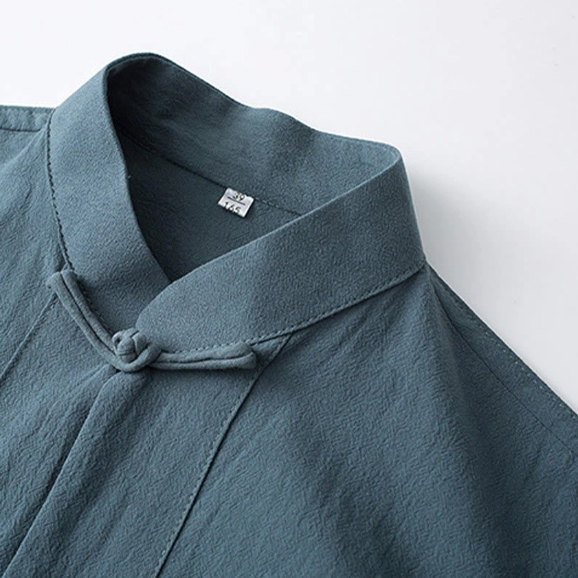 Close-up of Tang suit stand collar with hand-finished frog button and fabric detail label