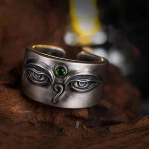 925 sterling silver Bodhisattva Tara adjustable ring with hand-engraved eye motif and green gemstone, displayed on antique wooden platform showing front top-down view
