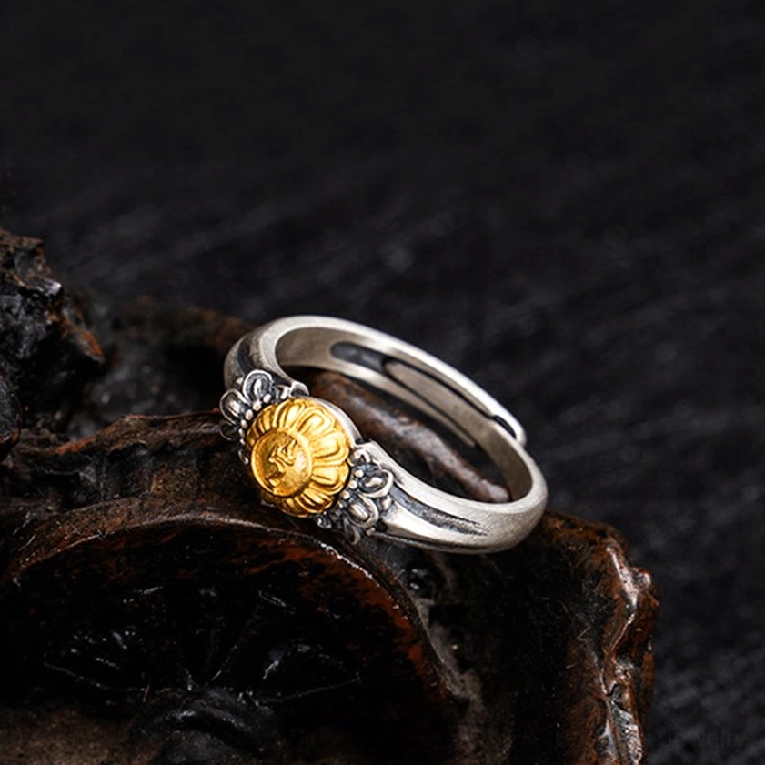 Tara protection ring low angle view displaying ornate floral silver accents flanking the central gold Bodhisattva emblem