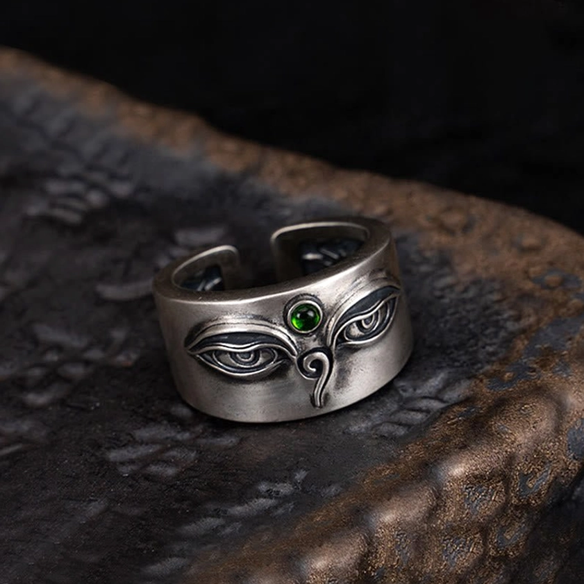 Back view of Tara adjustable silver ring featuring intricate carved patterns and green gemstone accent on dark stone surface