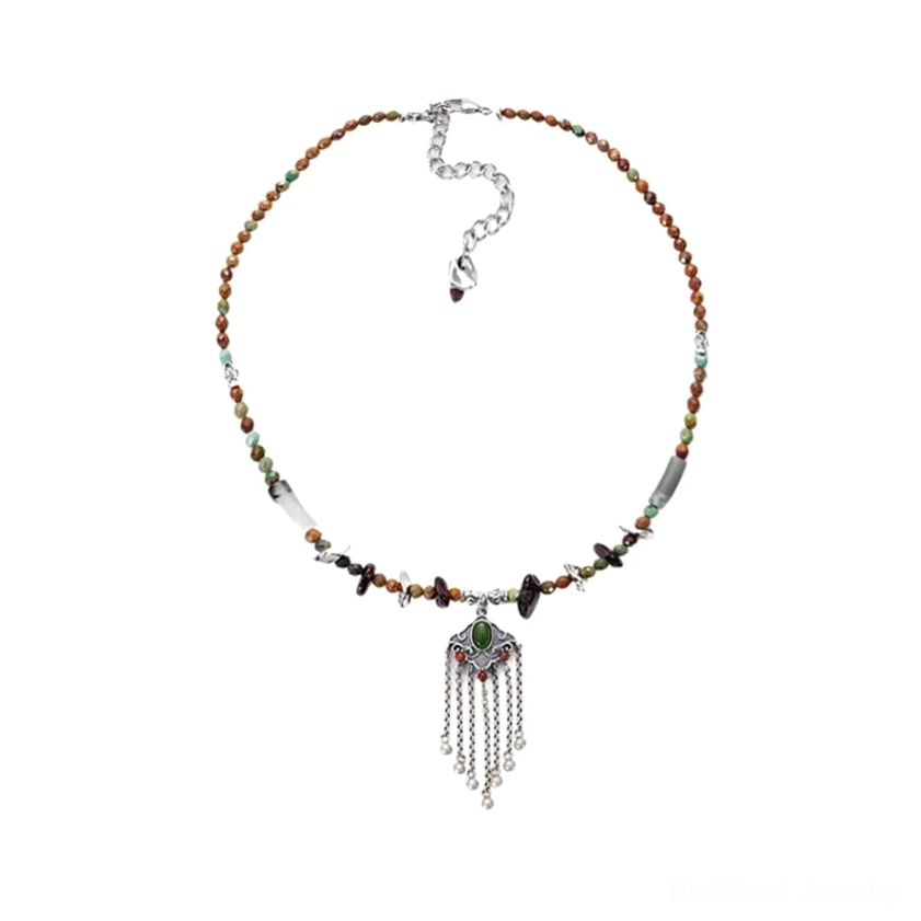 Overhead minimal flat lay view of tassel choker pendant necklace featuring tiny mixed gemstone beads, silver tassel charm, and extender chain for versatile styling